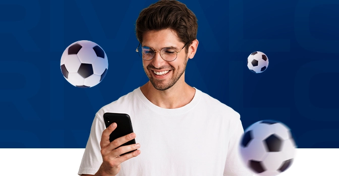 Imagem mostra torcedor comemorando com smartphone e bola em mãos